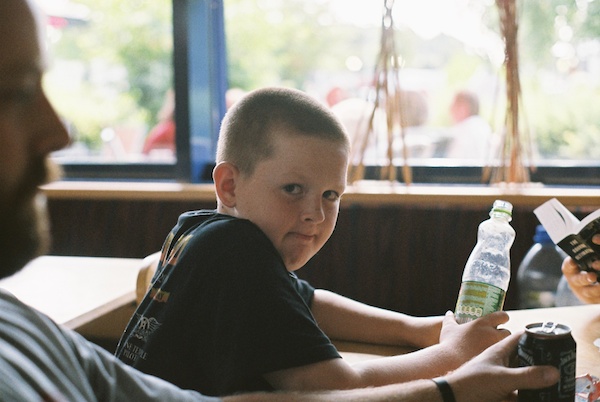 A boy holding a bottle looks at the camera - Window Light for Portraits