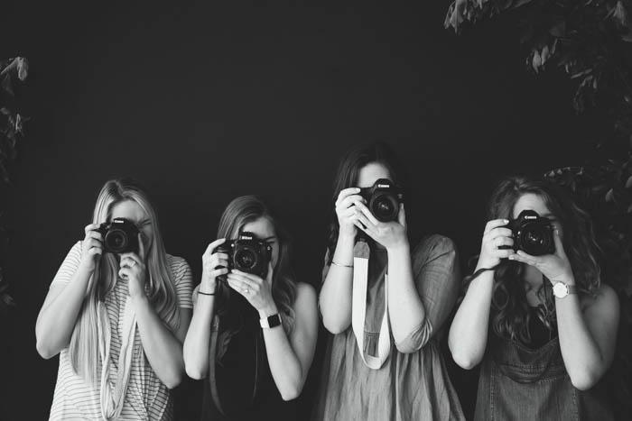Μια ασπρόμαυρη φωτογραφία τεσσάρων αρχάριων φωτογράφων που κρατούν κάμερες DSLR