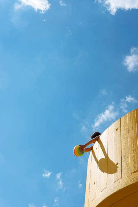 Μια φωτεινή και ευάερη φωτογραφία ενός παιδιού που παίζει σε έναν πύργο ενάντια σε έναν μπλε ουρανό, που δείχνει τον κανόνα των τρίτων στη φωτογραφία