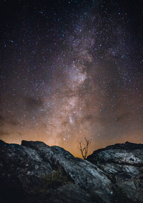 een prachtige sterrenhemel over een rotsachtig landschap
