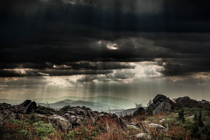 Fotografia de paisagem Moorland com godrays através de uma nuvem densa.