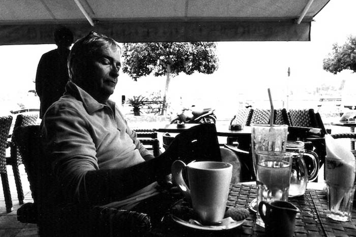 Um homem sentado a uma mesa filmado em filme fotográfico preto e branco 