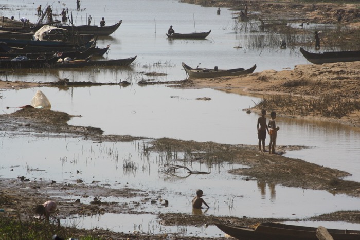 Una imagen de niños africanos cerca de un río seco.