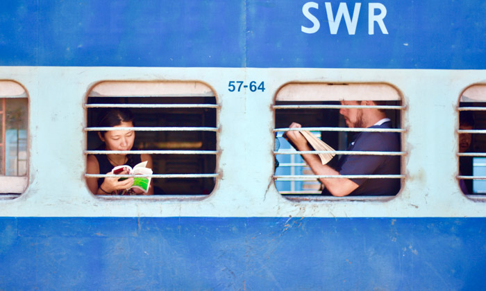 A travel photograph of people reading books on a train