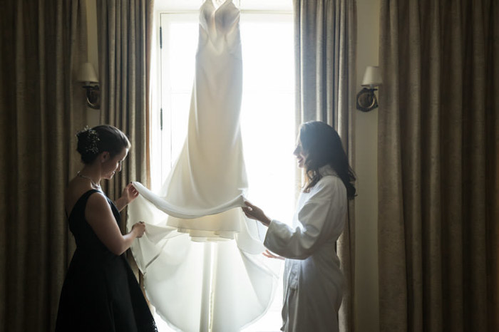 Two women inspecting a wedding dress