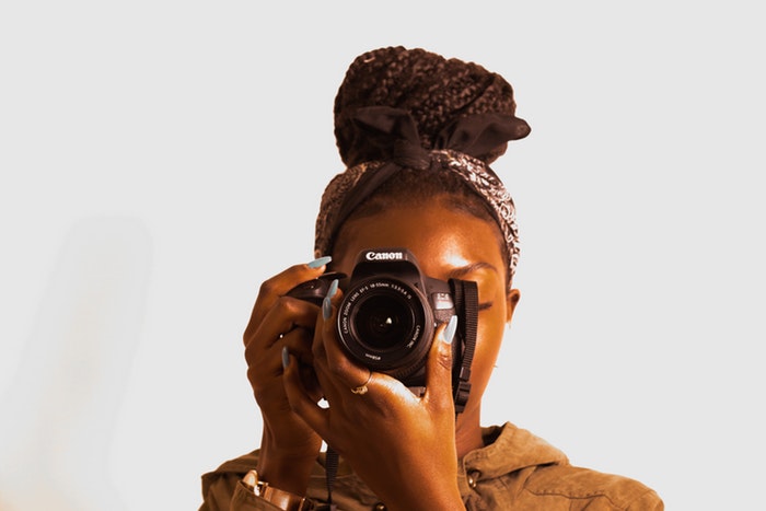 Mulher fotografando com uma câmera Canon DSLR