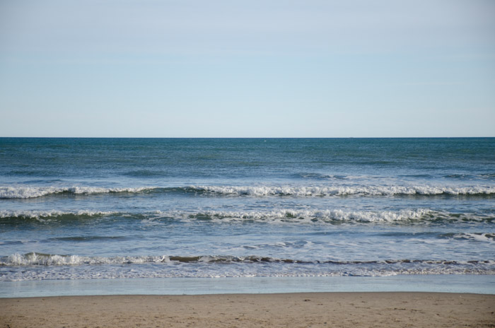 Una foto de la orilla del mar rodado sin un filtro polarizador.