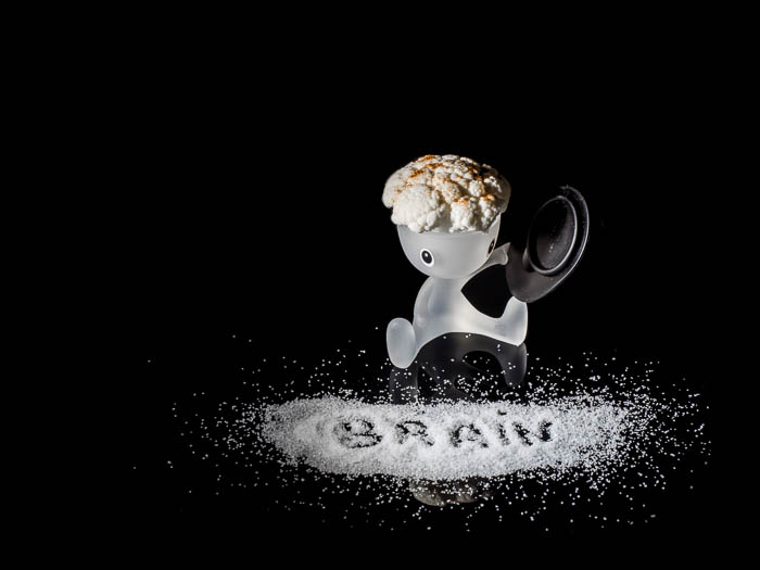 Una foto creativa de un bodegón con una huevera alessi, coliflor y sal 