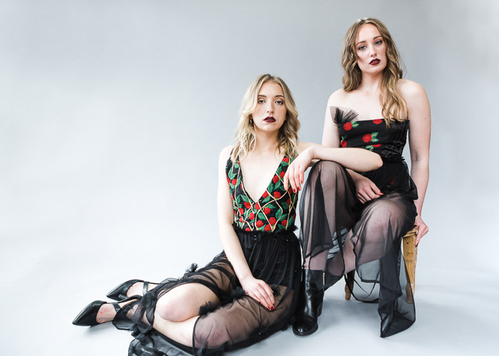 Duas modelos femininas posando em um estúdio fotográfico
