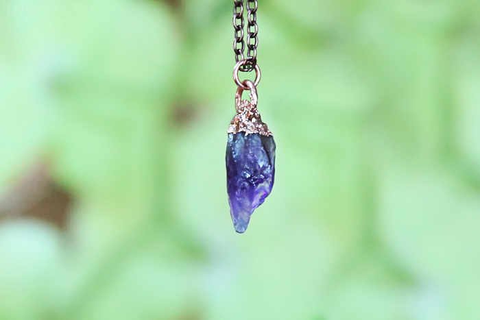product photography of a roughly cut gemstone pendant
