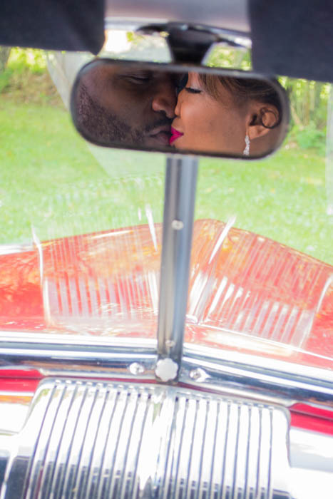 Reflexo no espelho do carro de um casal recém-casado beijando