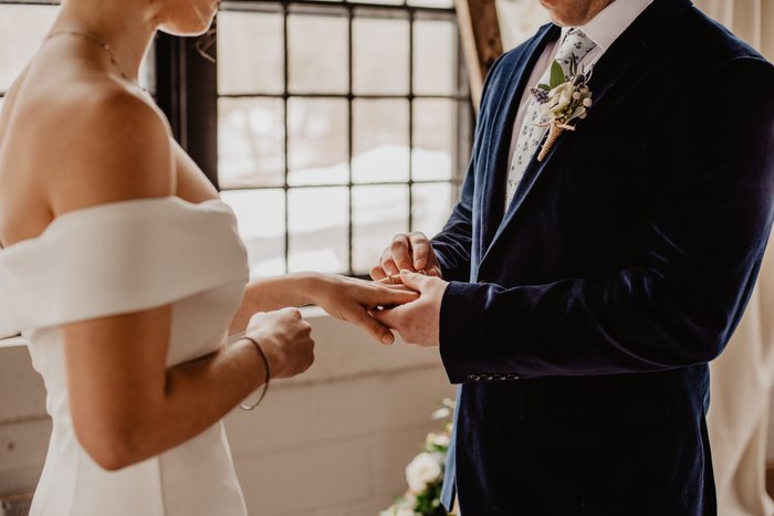 Close-up da noiva e do noivo de mãos dadas durante uma cerimônia de casamento