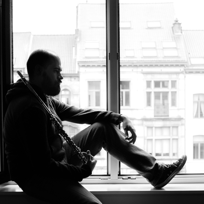 retrato preto e branco de homem sentado em uma janela