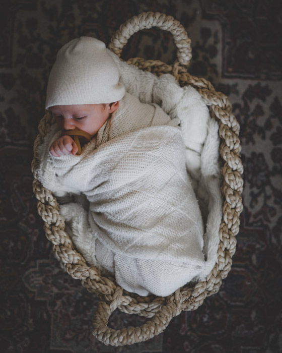 Um recém-nascido dormindo em uma cesta.