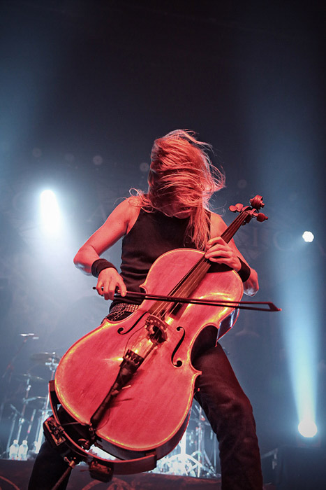 Uma garota tocando violoncelo elétrico no palco.