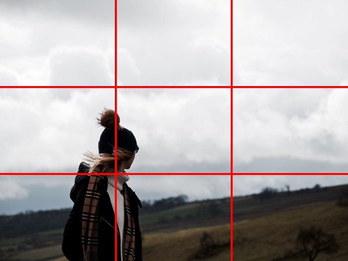 How to use the rule of thirds to position your subject to give your image interest and to help tell stories.  Girl stood in white turtle neck, hat and scarf looking up a hillside.  