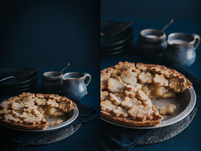 Colagem de fotos Diptych mostrando 2 ângulos diferentes de uma torta de maçã assada com pratos, talheres e fundo azuis.