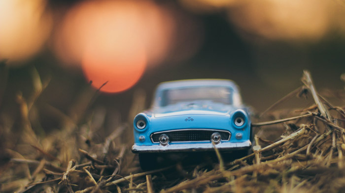 Una foto di un'auto blu giocattolo sull'erba