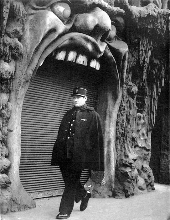 Fotografia em preto e branco de um homem caminhando pelo bar L'Enfer em Paris 