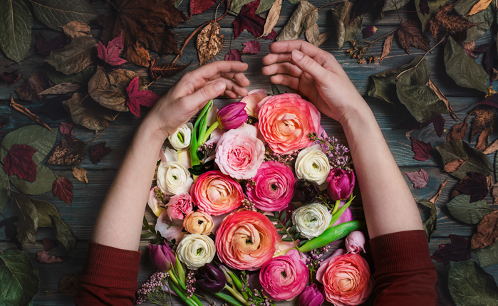 Overheadshot van iemands armen die bloemen vasthoudt op een donkere achtergrond - stillevenfotografie-ideeën.