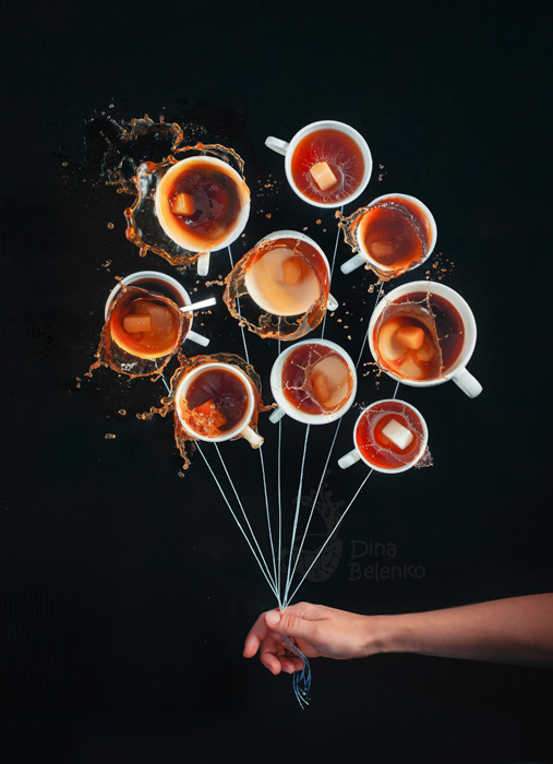 Eine verspielte Food-Fotografie einer Person, die bis zu neun Kaffeetassen hält, als ob sie einen Haufen Luftballons halten würden