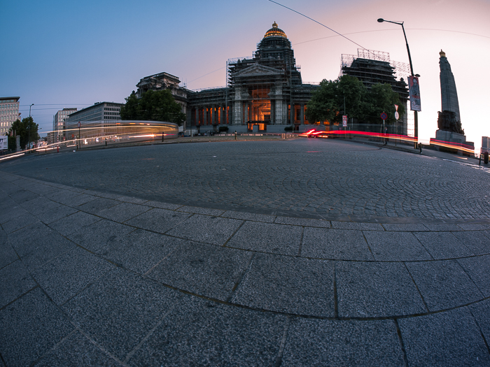 Leichte Verkehrsspuren vor einem großen Gebäude am Abend