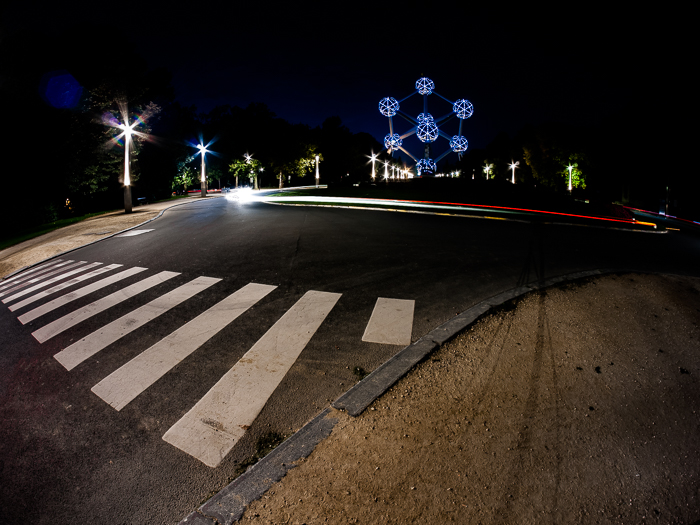 Une scène nocturne urbaine avec des sentiers de lumière rouge pris autour d'un rond-point à Bruxelles