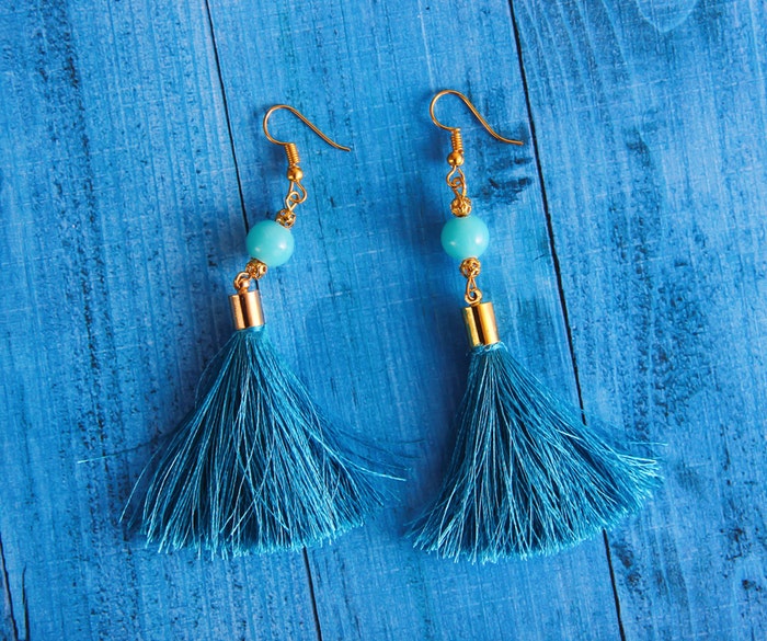 blue earrings on a blue background