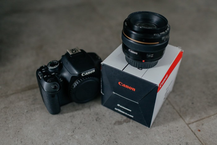 Uma câmera Canon com lente 50mm cinqüenta prime no topo de sua caixa de embalagem