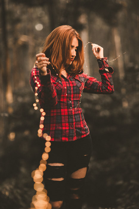 Foto de una chica con una cadena de luces de hadas