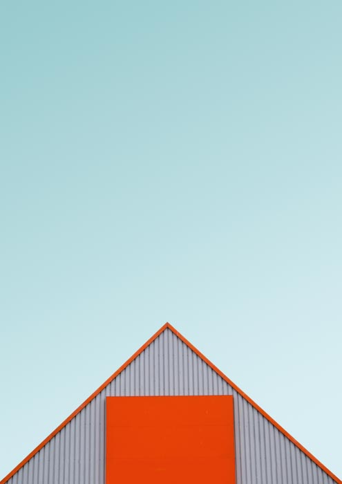 Foto atap oranye gudang atau gudang di atas langit biru 
