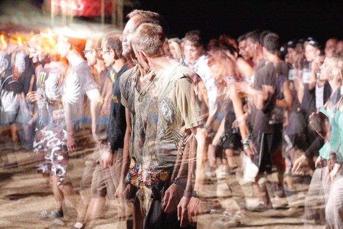 Una foto sfocata di un gruppo di persone che camminano di notte scattata con un tempo di posa lento