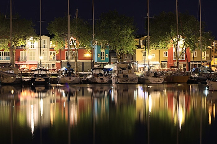 Een prachtige nachtopname van boten in een haven met een prachtig patroon dat wordt weerspiegeld in het water