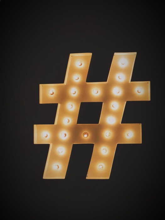 Un hashtag Instagram dorato su sfondo nero