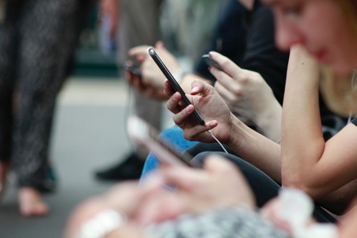 Foto borrosa de una gente revisando sus teléfonos en un tren lleno de gente