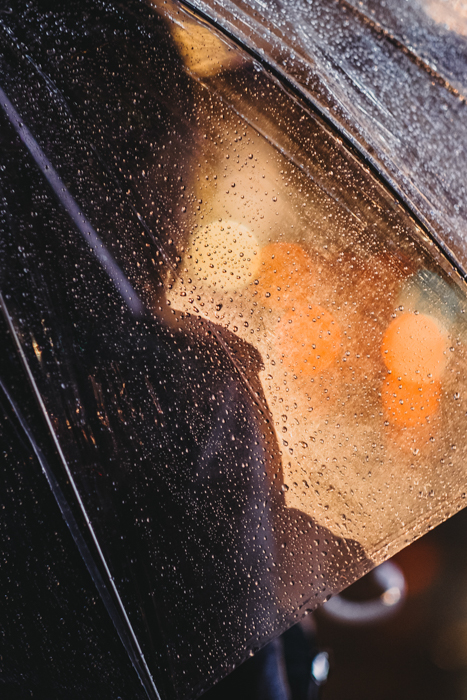Retrato de uma pessoa sob um guarda-chuva respingado de chuva