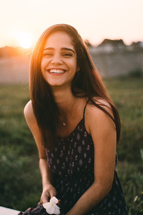 Un ritratto all'aperto di una donna bruna sorridente per una bella foto del profilo