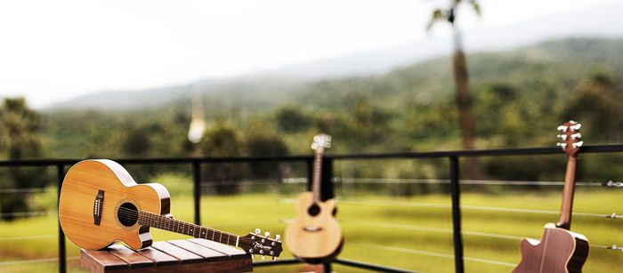 Uma guitarra apoiada em uma mesa ao ar livre fotografada com lente grande angular