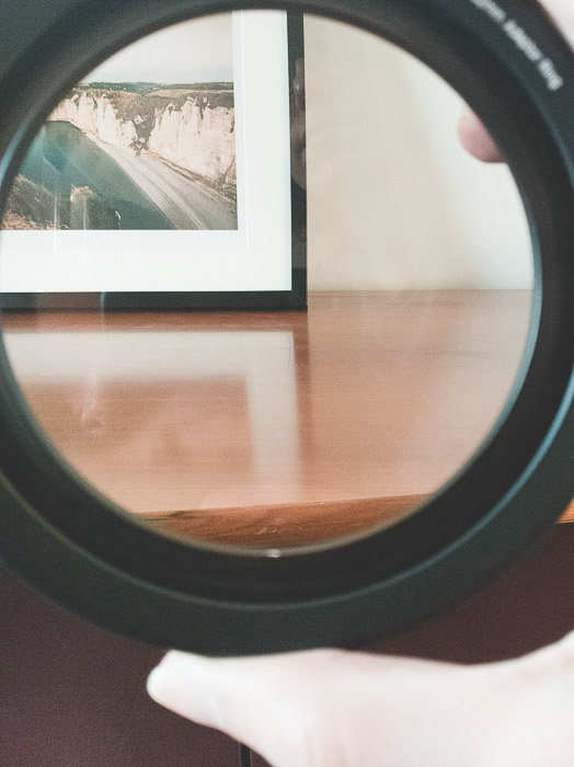 una mesa y un marco de fotos con reflejos en la madera vistos a través de un objetivo de cámara CPL filtro