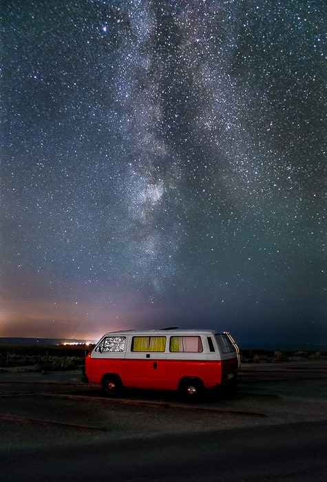 A van parked right in front of the Milky Way.