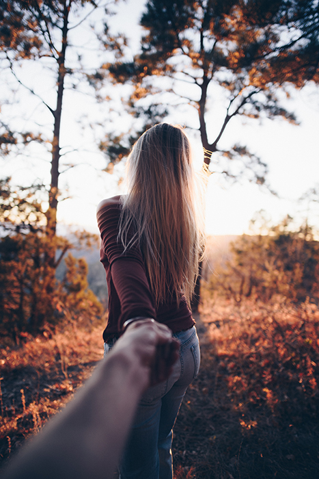 Um casal posando em uma floresta para uma sessão de fotos do Dia dos Namorados