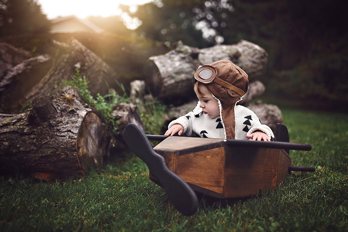 Una foto conceptual de un niño pequeño en un barco de madera al aire libre