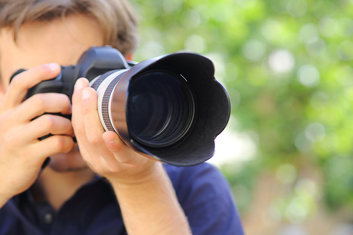 Un fotografo che scatta con una fotocamera DSLR - capire le diverse parti della fotocamera