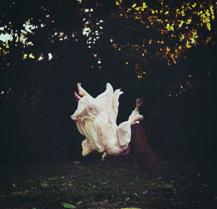 Surreal fine art portrait of a female model falling outdoors