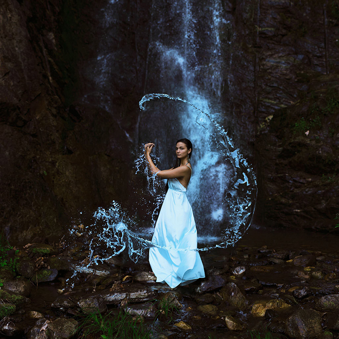 Artistic portrait of a female model posing under a waterfall by Sarah Ann Loreth 