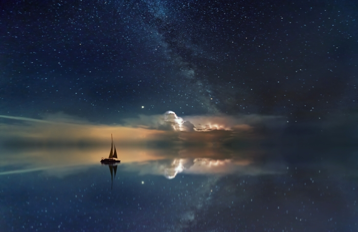 Une image éditée d'un voilier flottant dans la mer avec un ciel étoilé