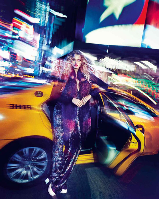 Potret mencolok dari model fesyen wanita berpose dengan taksi - fotografi mode luar ruangan di malam hari