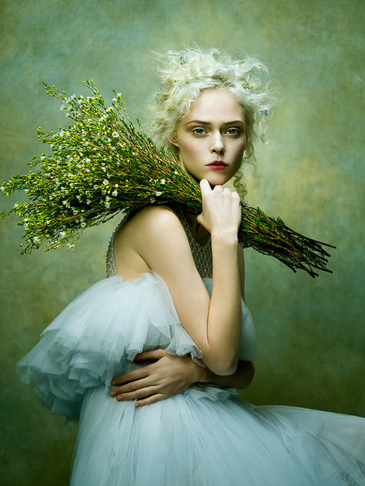 Potret busana bergaya pictorialist dari model wanita berpose dengan latar belakang hijau