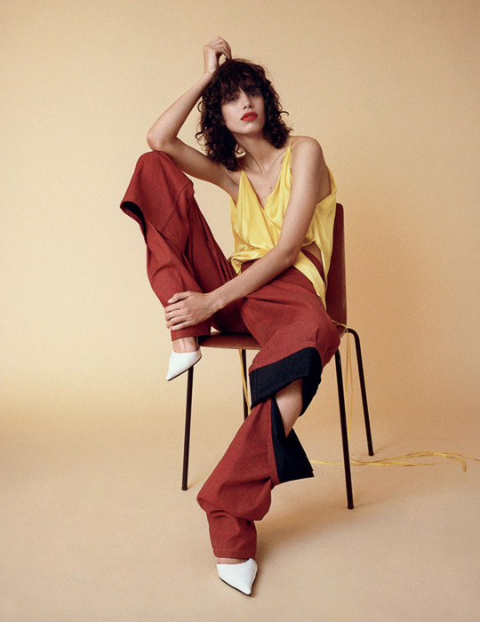 Model wanita berpose di kursi dengan latar belakang kuning pucat - inspirasi foto mode 