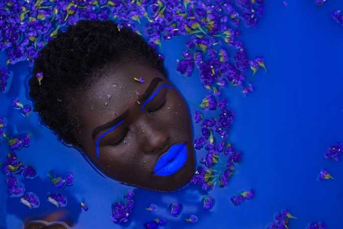 Visage de femme maquillée en bleu dans de l'eau bleue's face with blue make up in blue water